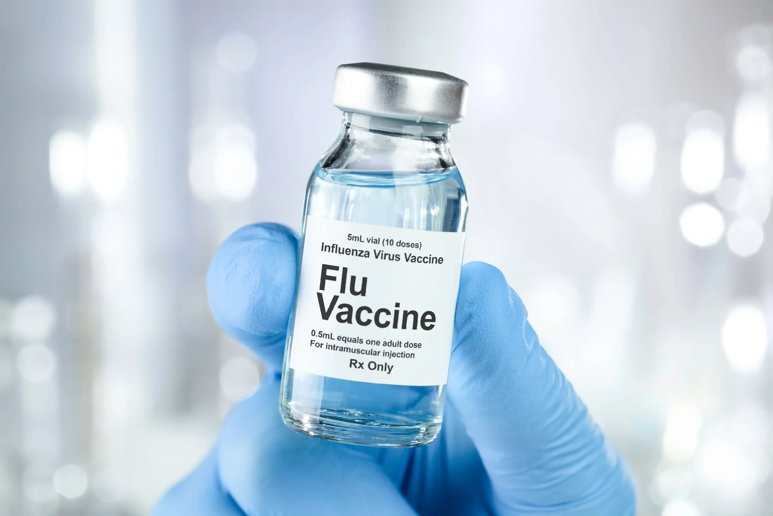 Nurse holding flu vaccine vial