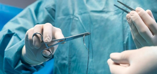 Surgeon performing a minor procedure in clinic